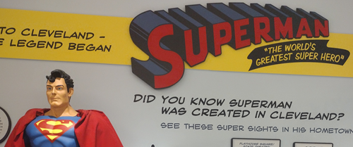 A statue of Superman, standing in front of a display with facts about his creation. "Did you know Superman was created in Cleveland?"