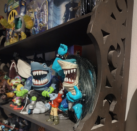 A crowded shelf full of 90s toys and action figures, with the focus on two Street Shark characters.