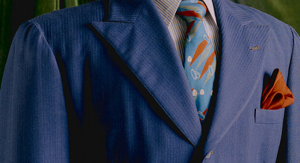 An indigo zoot suit, with a red kerchief in its chest pocket.