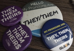 A variety of they/them pronoun pins.