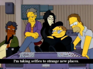 The Simpsons meme of Homer, Seymour, Apu, Barney, and Yoko-Ono-Reference in the studio. Barney is sitting and dressed like an artie beatnik. Caption reads "I'm taking selfies to strange new places."