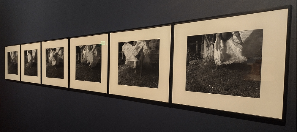 A series of black and white photos in black frame, a Black femme body dancing in a white skirt can be seen from the waist down.